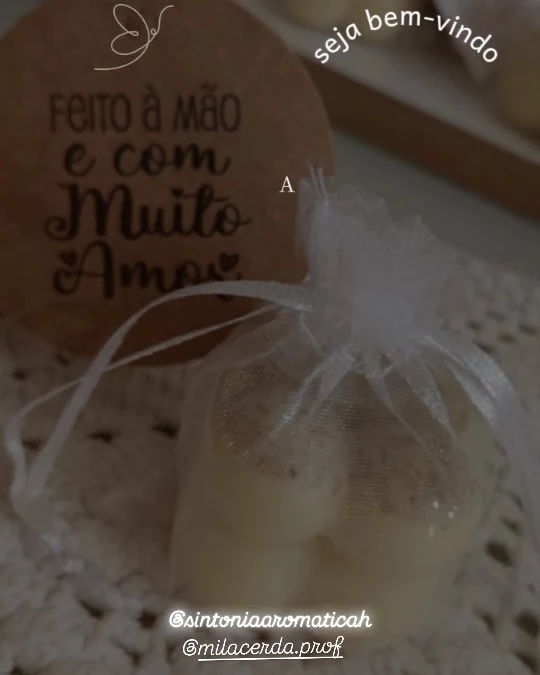 Sabonete num saquinho de organza, ao lado da etiqueta "Feito à mão e com muito amor"